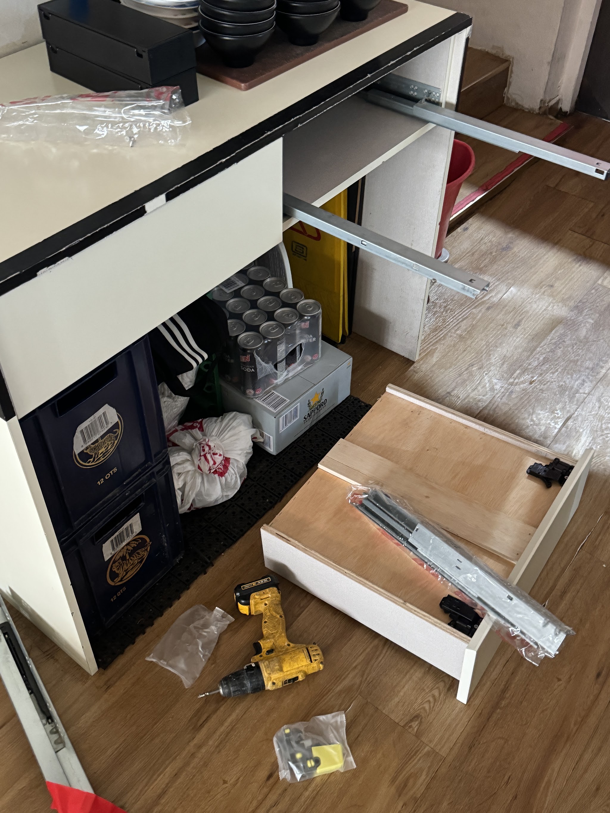 Drawer runners being replaced in a bar counter, the drawer out on the floor